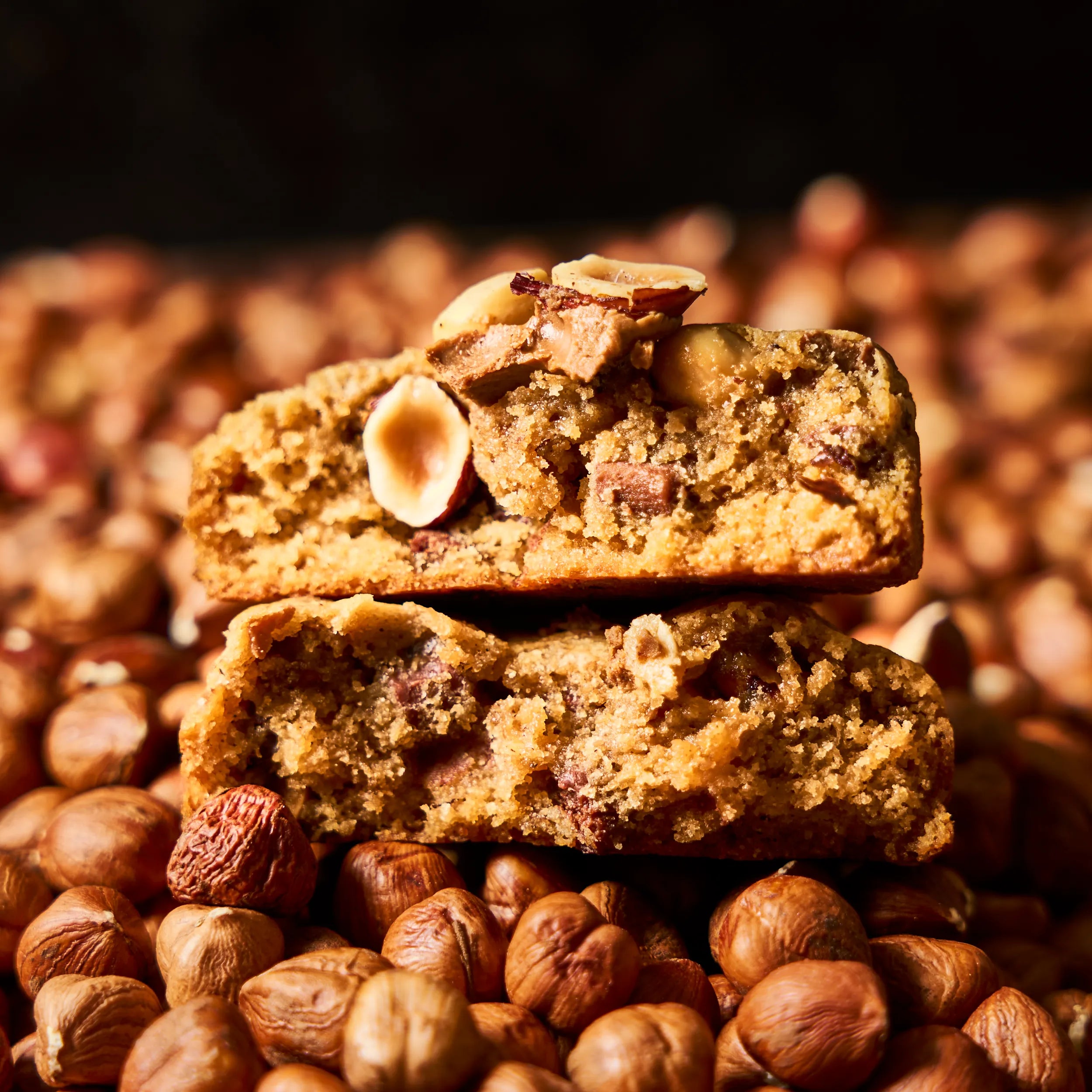 Vue en coupe du cookie chocolat au lait et noisette de Jeffrey Cagnes, révélant sa texture moelleuse et fondante enrichie d'éclats de noisettes.