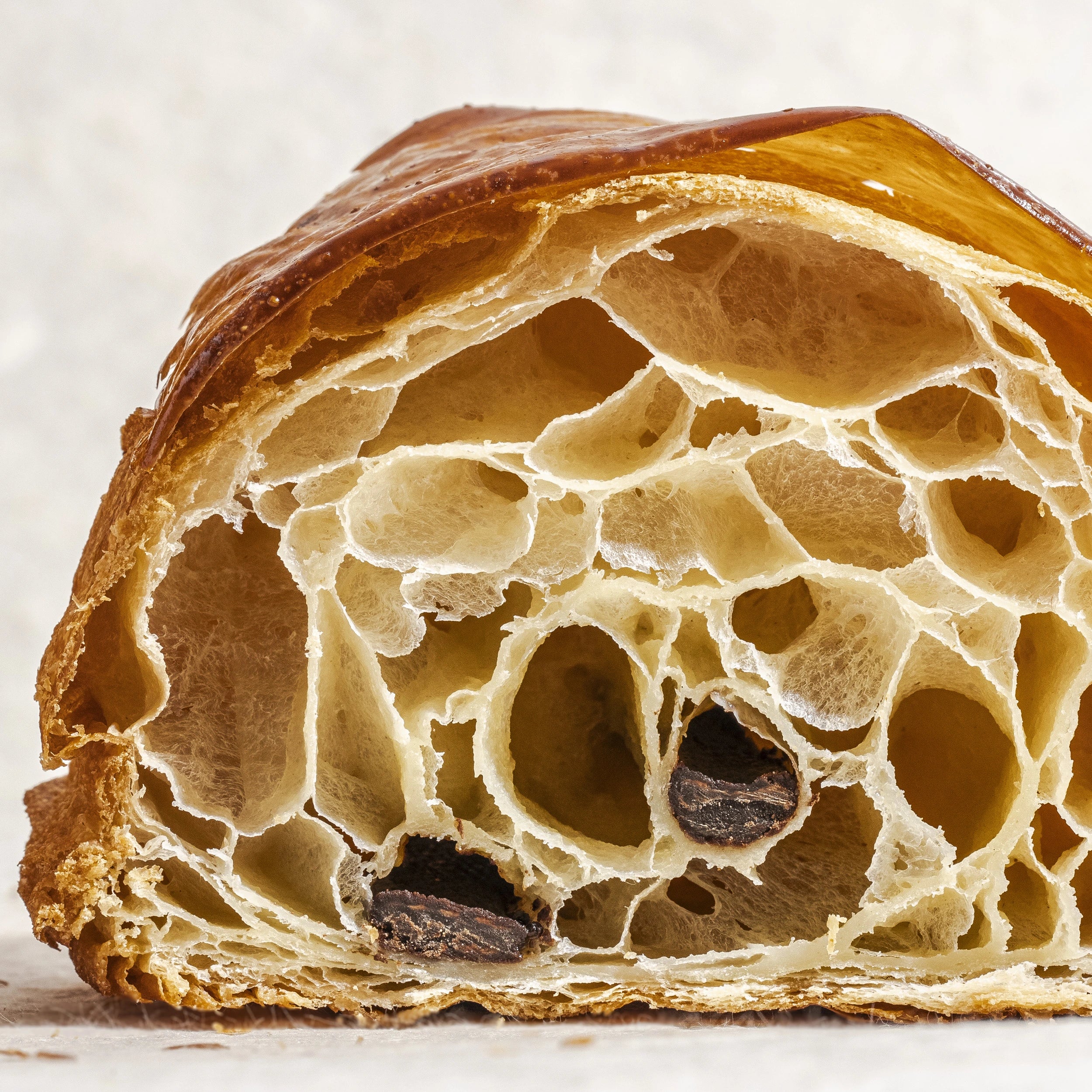 Gros plan macro sur l'alvéolage aérien et la mie fondante d'un pain au chocolat Jeffrey Cagnes.