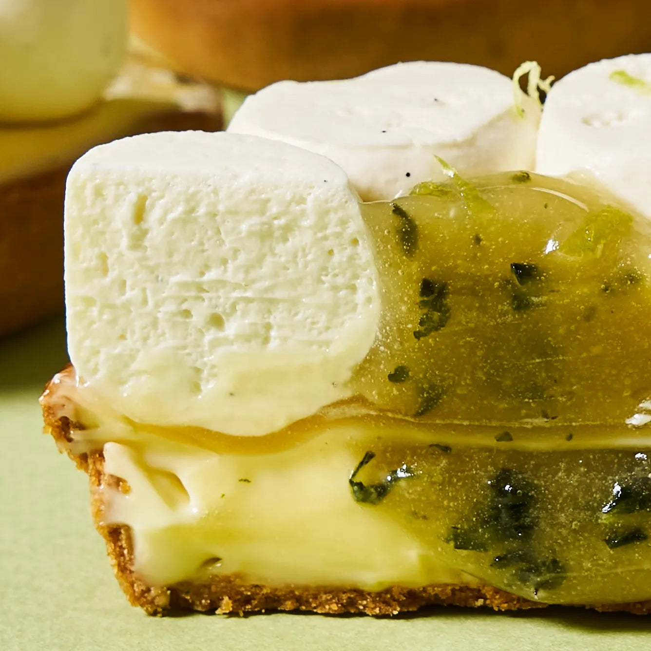 Zoom macro sur la texture fondante du crémeux et l'onctuosité du confit au basilic et à l'huile d'olive d'une tarte de Jeffrey Cagnes.