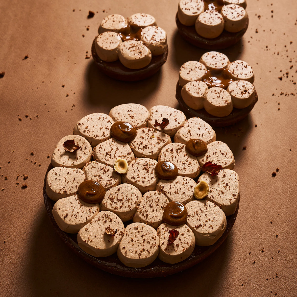 Présentation de la tarte chocolat tonka en format familial aux côtés des entremets individuels.