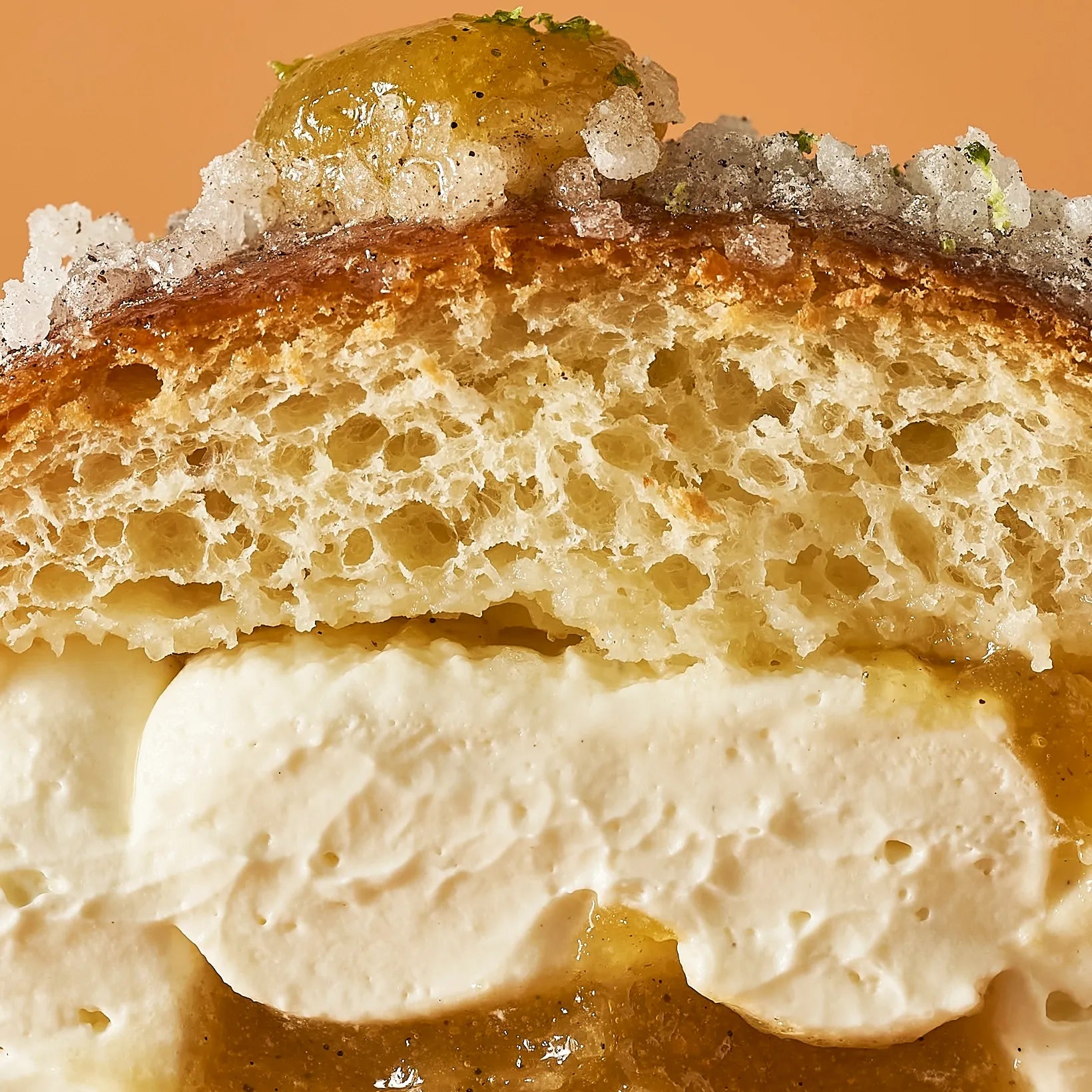 Coupe transversale montrant l'imbibition de la brioche, la généreuse crème montée et l'insert de confit orange, citron vert et vanille de Madagascar.