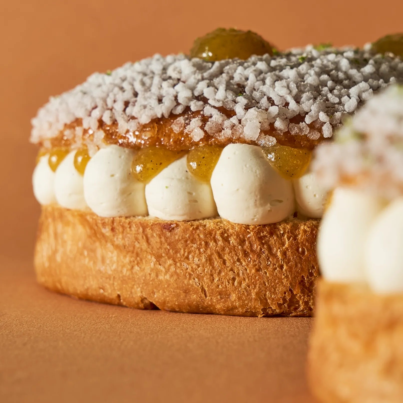 Vue rapprochée du pochage régulier de crème montée à la fleur d'oranger et de la brioche moelleuse de la Tropézienne Jeffrey Cagnes.