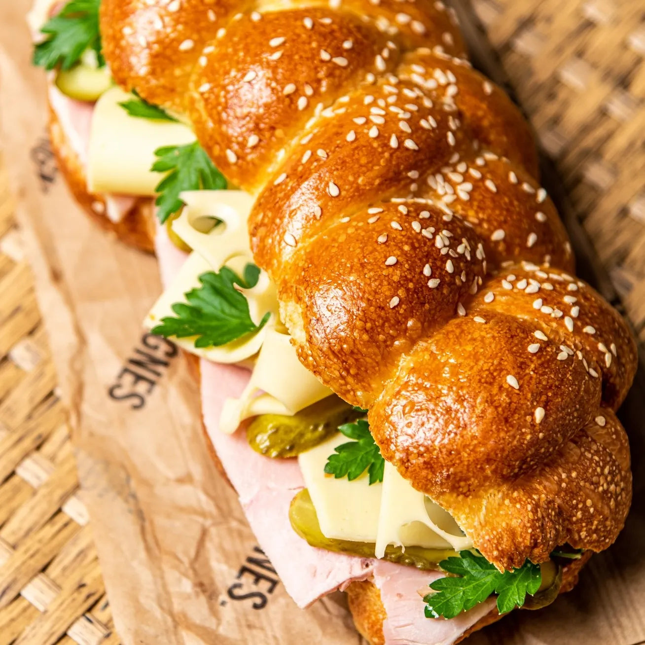 Sandwich Le Parisien de Jeffrey Cagnes dans son pain Hallot tressé aux graines de sésame, garni de jambon, emmental et persil.