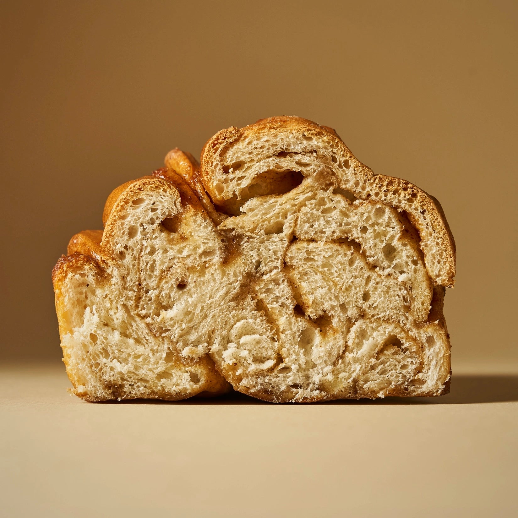 Coupe transversale d'un cinnamon roll montrant une mie de brioche ultra moelleuse et alvéolée.