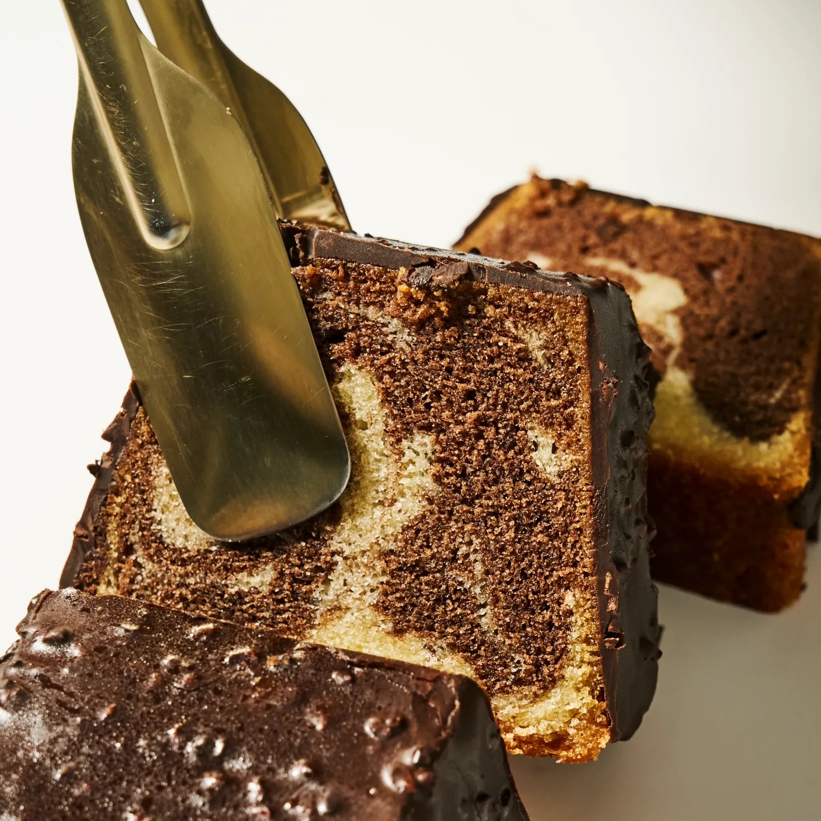 Gros plan sur la marbrure vanille-chocolat ultra-fondante et le craquant du glaçage rocher amande du Chef Jeffrey Cagnes.