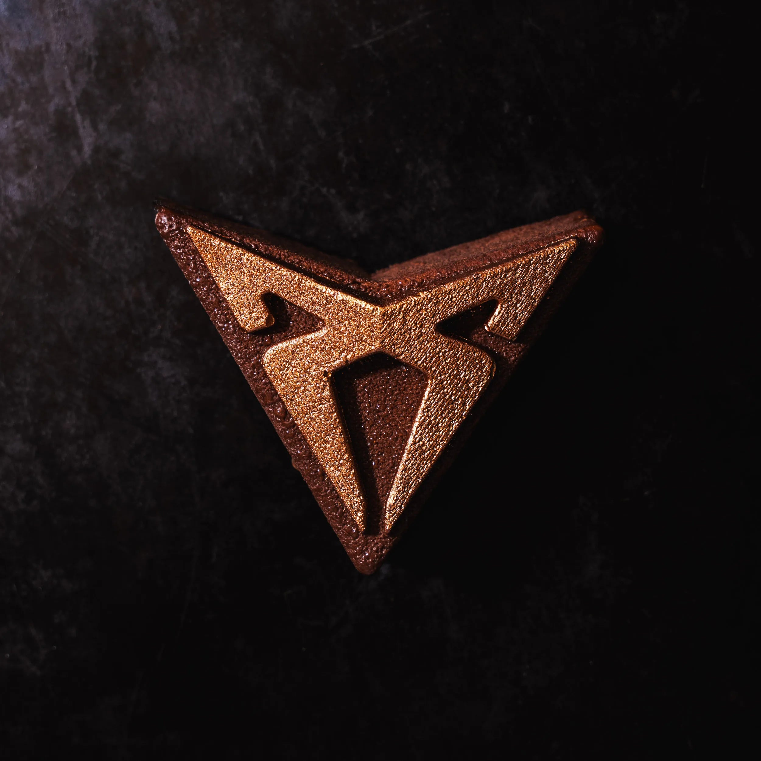 Vue de dessus symétrique et épurée de la création chocolatée exclusive Cupra par Jeffrey Cagnes sur fond noir.