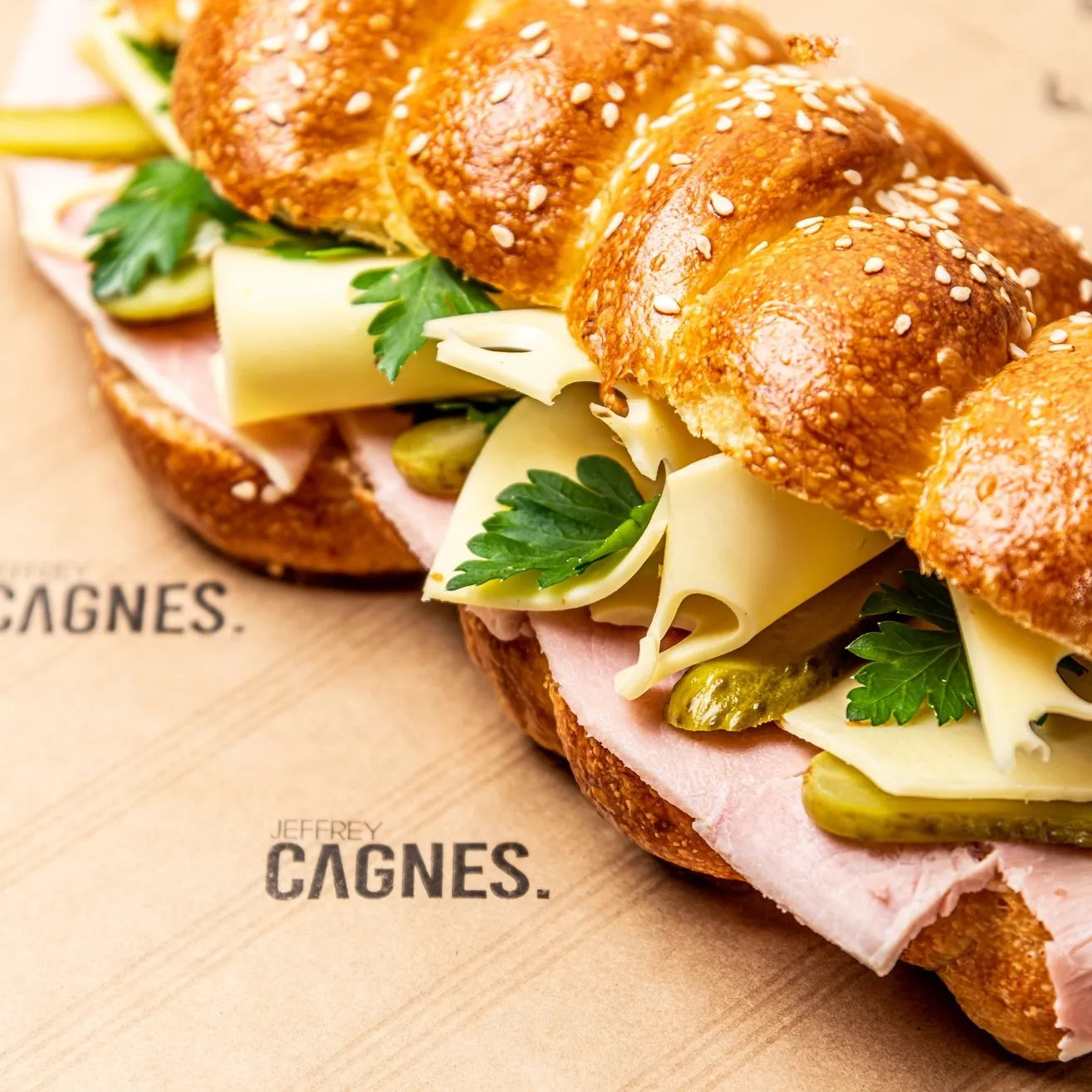 Gros plan sur les alvéoles de l'emmental, le beurre persillé et le jambon de Paris du sandwich Le Parisien Jeffrey Cagnes.