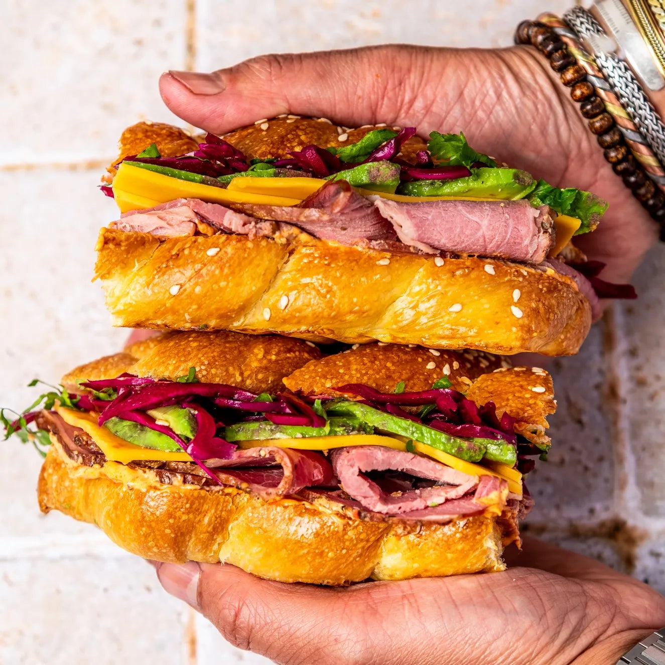Deux moitiés de sandwich Pastrami superposées montrant la mayonnaise spicy et l'avocat frais.