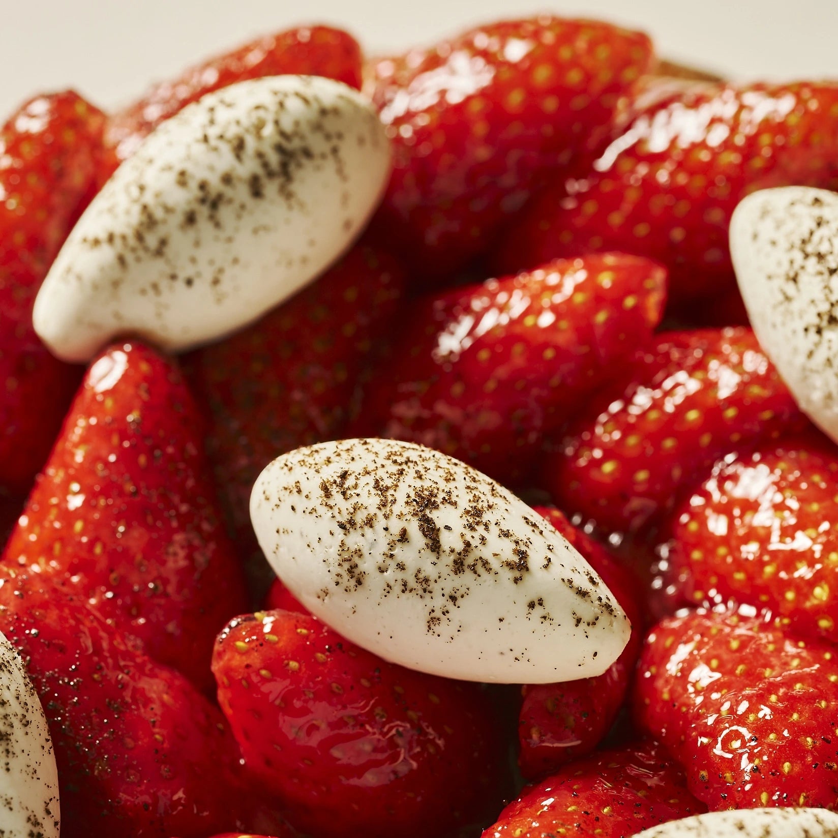 Gros plan sur les fraises fraîches et la quenelle de chantilly vanille mascarpone poudrée de vanille.