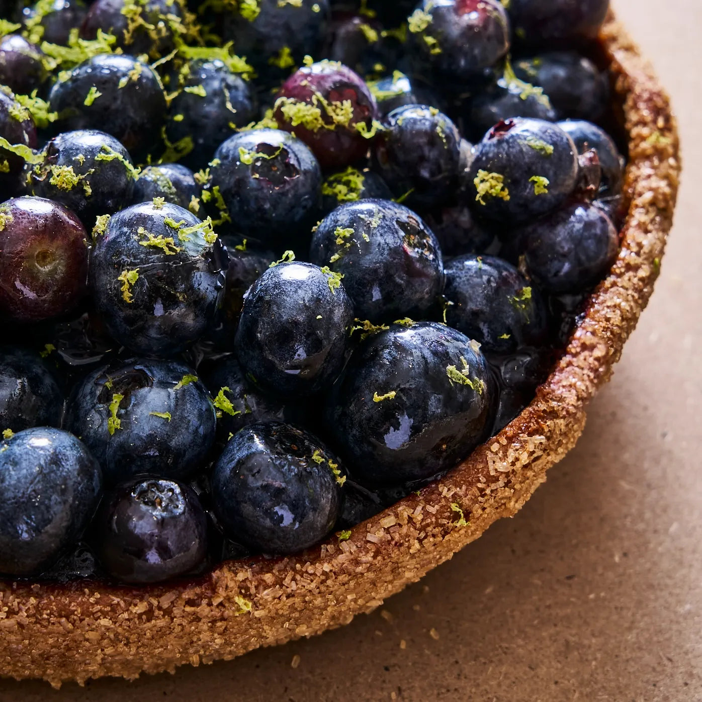 Détail de la bordure de pâte sucrée dorée et caramélisée enrobée de sucre fin.