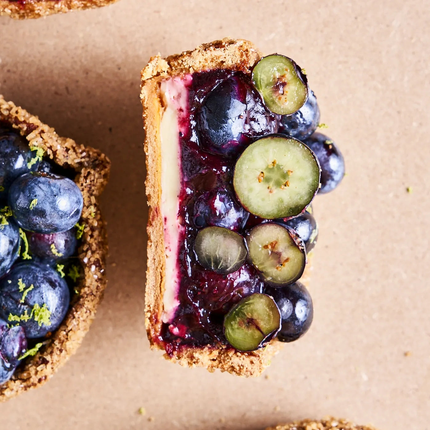 Vue plongeante de la coupe d'une tarte aux myrtilles dévoilant l'épaisseur du confit de fruits et la pâte caramélisée.