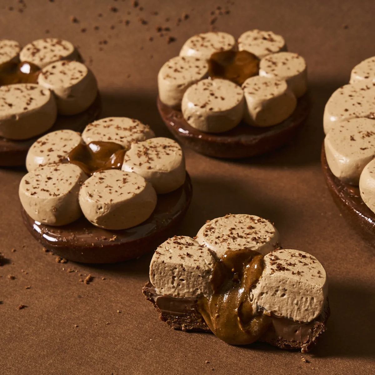 Vue en coupe spectaculaire de la tarte chocolat tonka révélant le praliné pur ultra-coulant et le crémeux chocolat noir 64%.