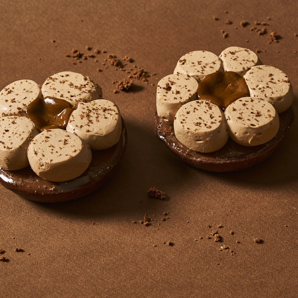 Duo de tartes individuelles chocolat tonka signées Jeffrey Cagnes sur fond cacao chaleureux.