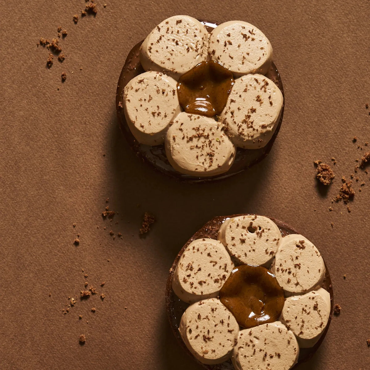 Vue de dessus d'une tarte chocolat tonka montrant la symétrie du pochage au chocolat au lait et le cœur généreux de praliné pur amande noisette.