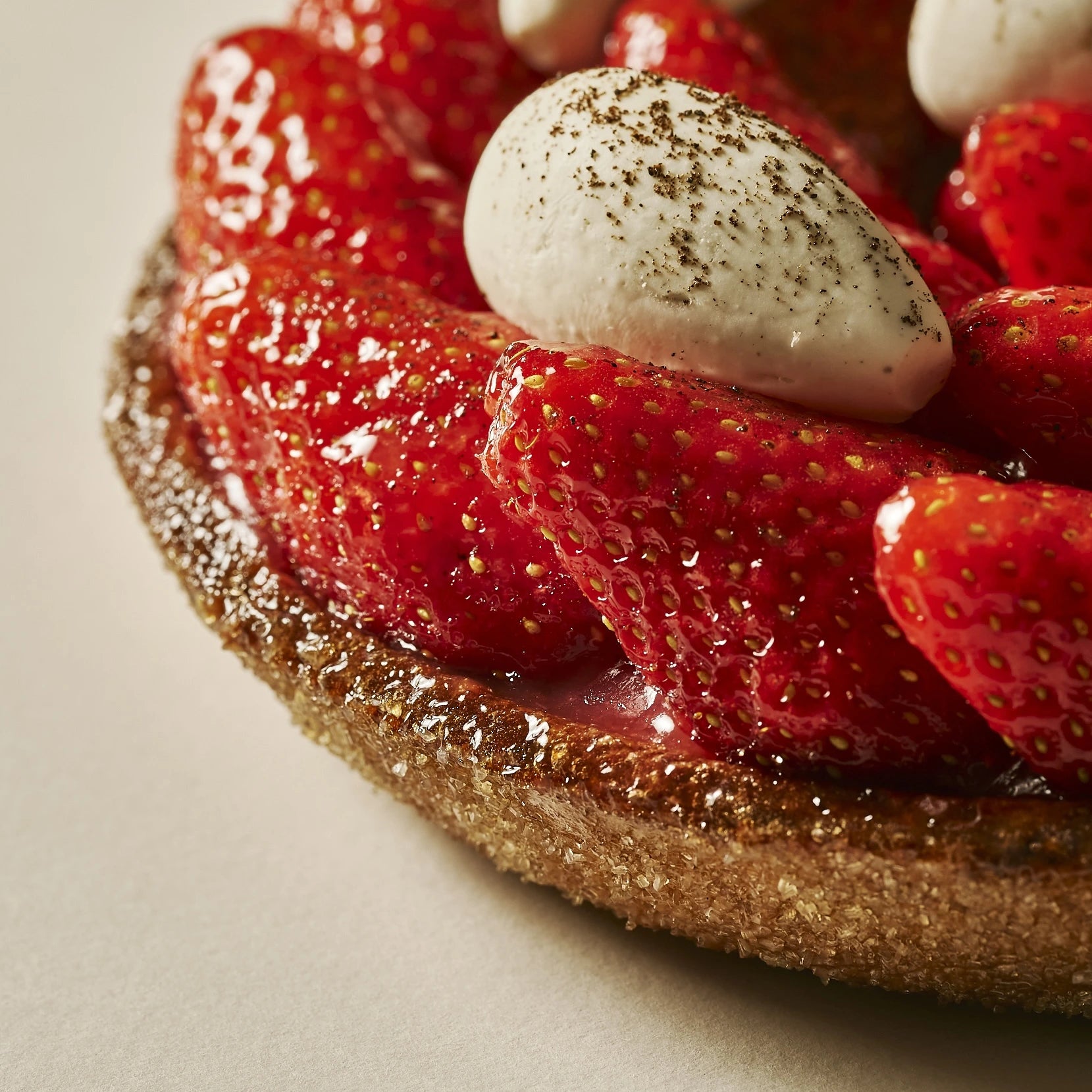 Détail du nappage brillant sur les fraises fraîches et du cœur au crémeux vanille.
