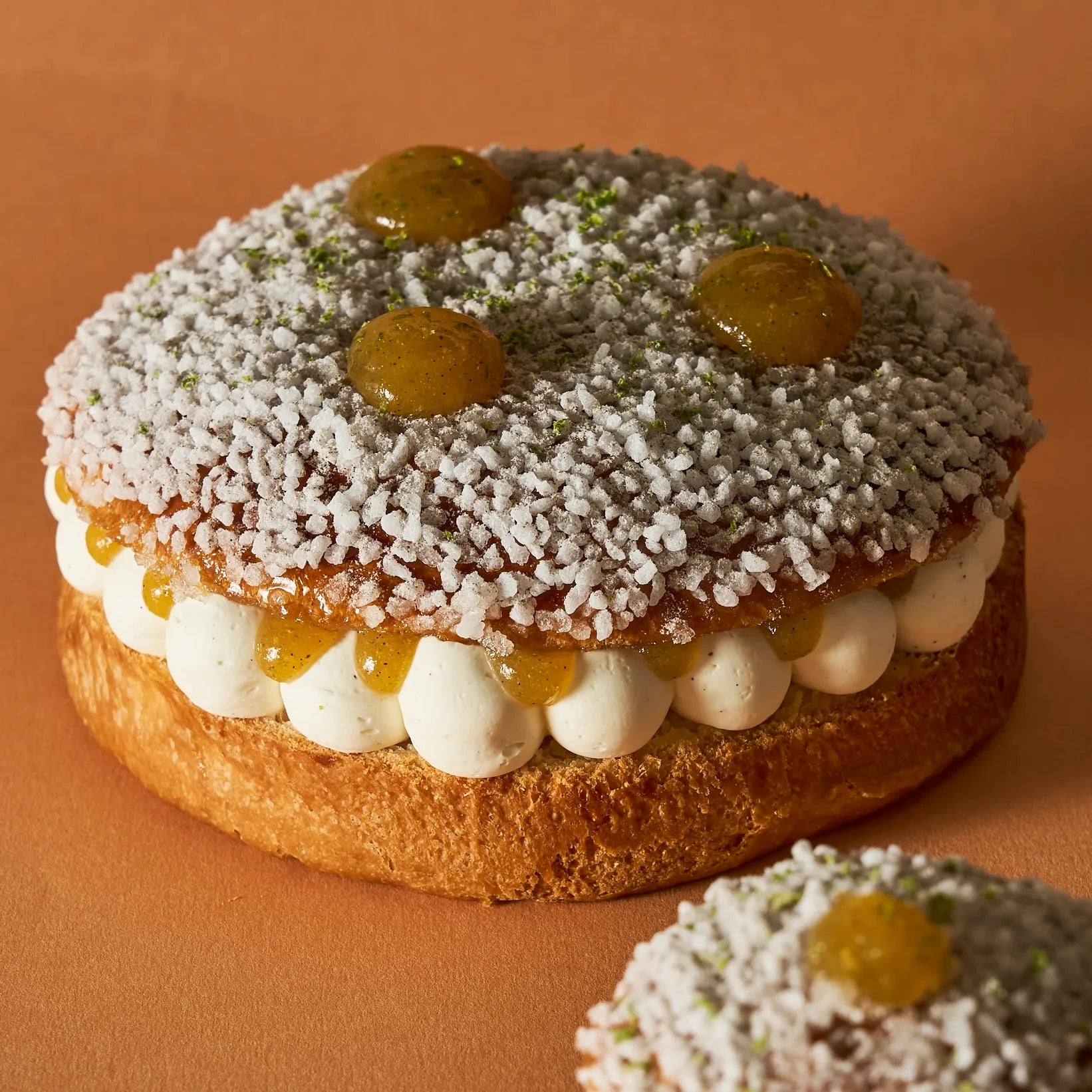 Tarte Tropézienne 6 personnes par Jeffrey Cagnes avec brioche imbibée à la fleur d'oranger, sucre grain craquant, crème montée et gouttes de confit orange et citron vert.